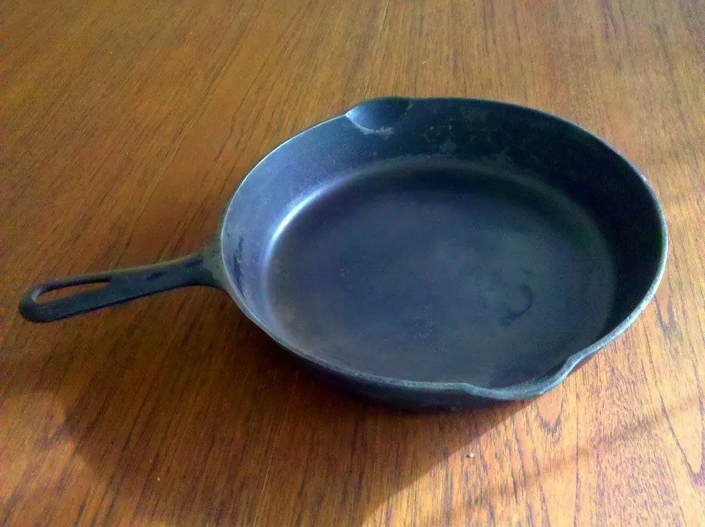A seasoned carbon-steel skillet resting on a wooden counter in the Leslieville workshop