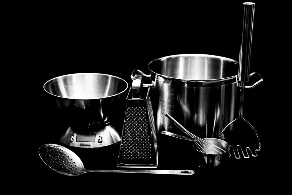 A pan, chef knife and folded linen arranged on the workshop table